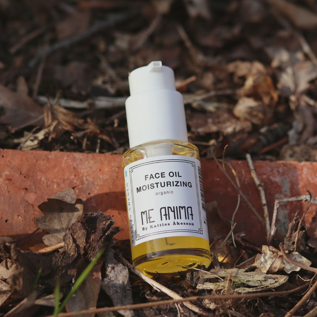 Me Anima Face Oil Moisturizing placerad i naturlig miljö med löv och jord ekologisk ansiktsolja som återfuktar och balanserar huden.