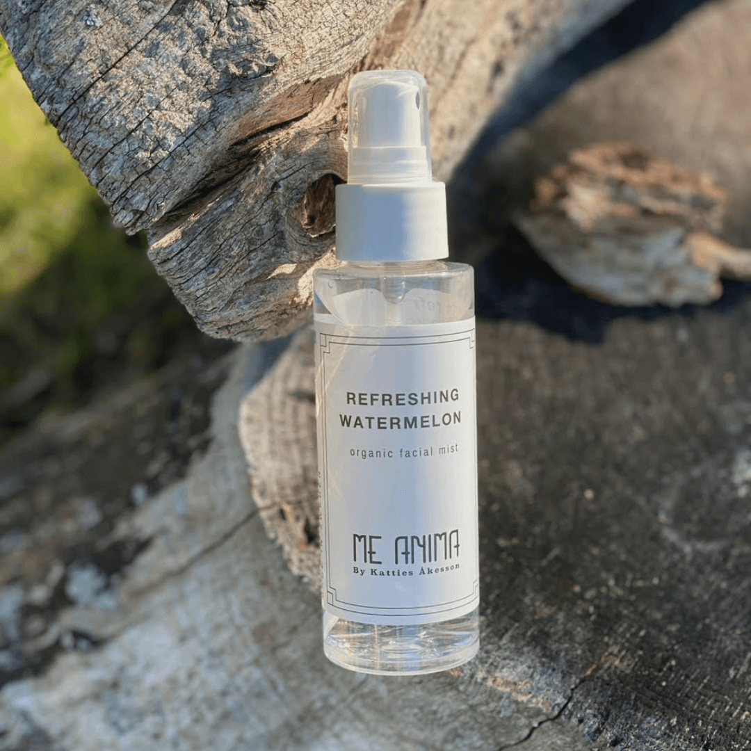Me Anima Refreshing Watermelon Facial Mist placerad på en träyta i solljus – ekologisk ansiktsmist som återfuktar och fräschar upp huden naturligt.