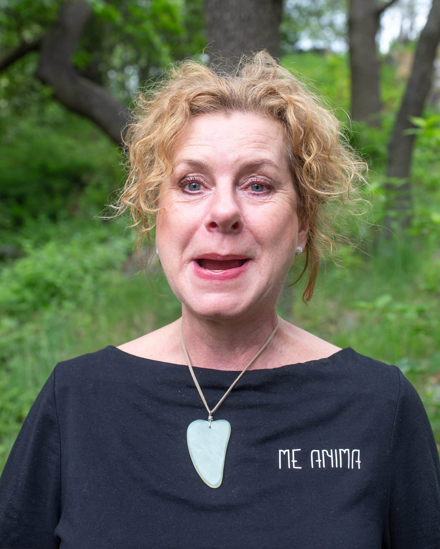 Katties Åkesson grundare av Me Anima visar ansiktsgympaövning i naturmiljö