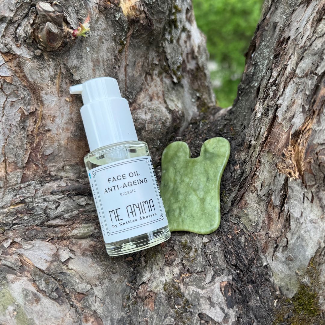 Me Animas Anti-Ageing Kit med Face Oil och grön Gua Sha fotograferad på trädstam – ekologiskt ansiktskit som vårdar och motverkar ålderstecken.