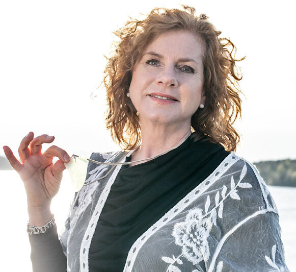 Katties Åkesson, grundare av Me Anima, visar en Gua Sha-sten – symbol för varumärkets naturliga hudvård och aromaterapi.