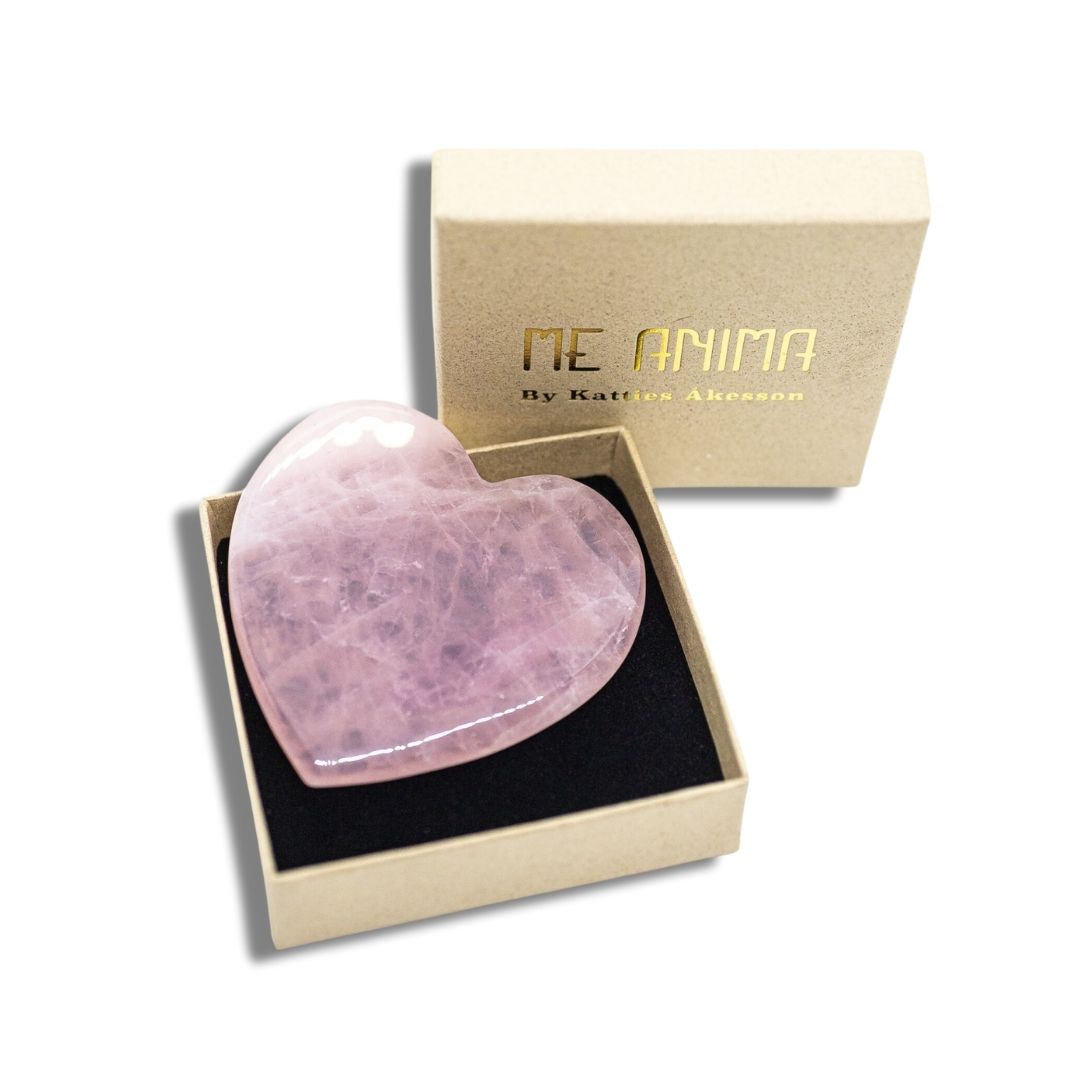Gua Sha i rosenkvarts från Me Anima formad som ett hjärta – levereras i elegant ask och används för ansiktsmassage som stimulerar lymfdränage, ökar cirkulationen och ger huden naturlig lyster.