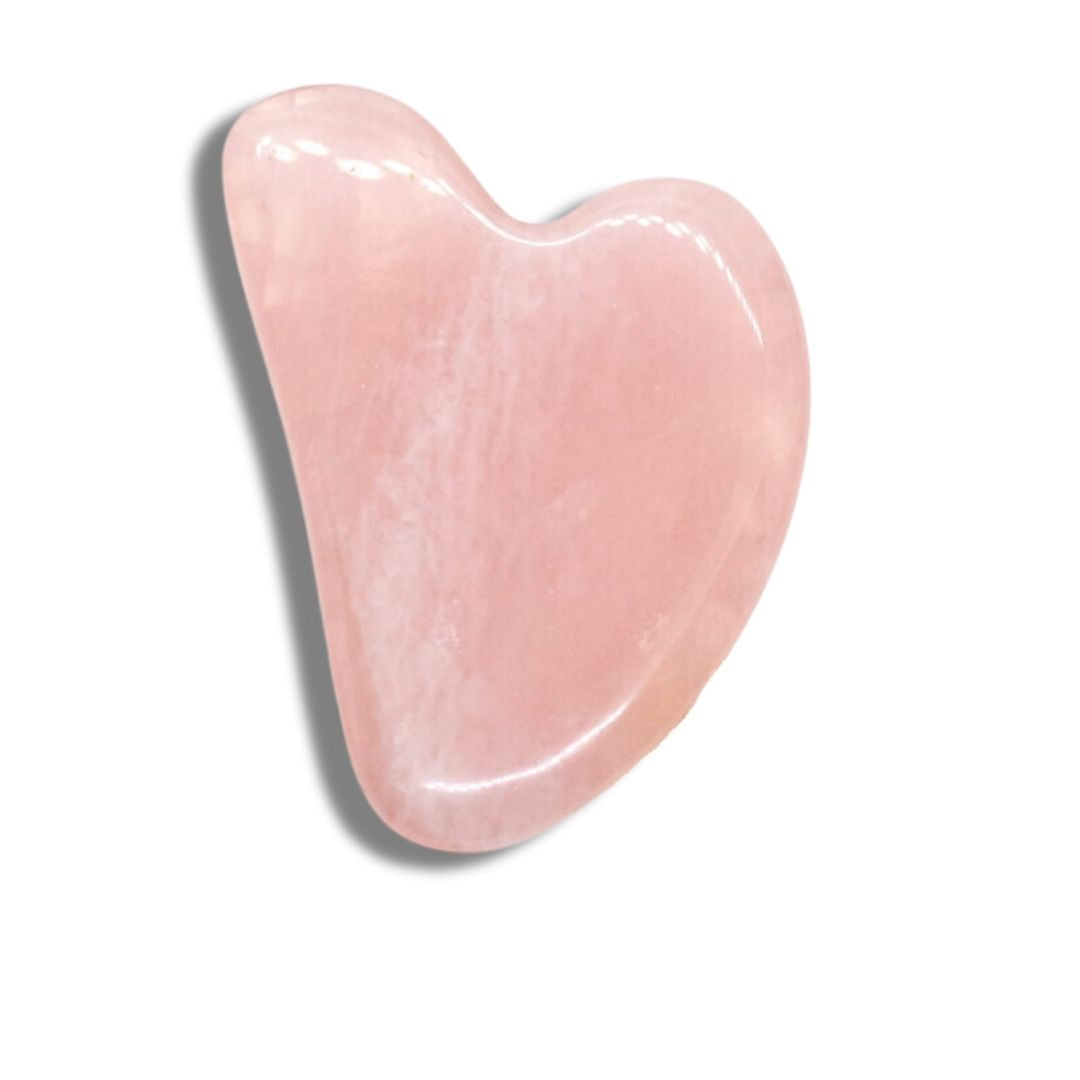 Gua Sha i rosenkvarts från Me Anima – ett hjärtformat massageverktyg som används för ansikts- och kroppsmassage för att öka blodcirkulation, minska spänningar och ge huden naturlig lyster.